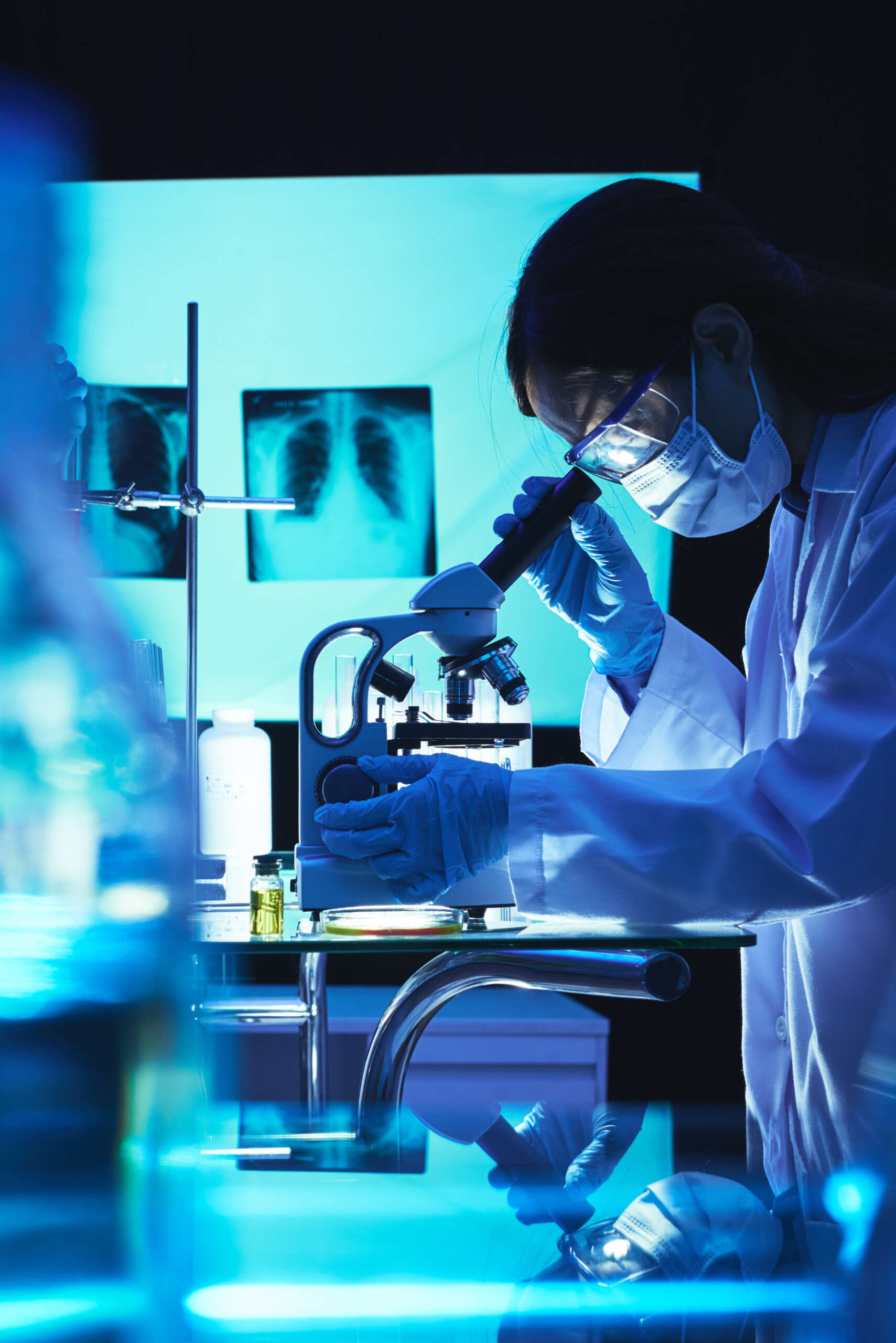 Una microbióloga profesional utiliza un microscopio en el laboratorio.